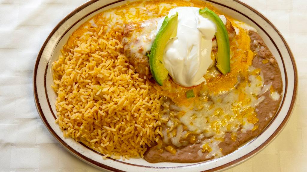 Chimichanga · A flour tortilla filled with your choice of beef chunks or shredded chicken, deep-fried until golden brown, topped with cheese sauce. Served with lettuce, sour cream, guacamole, and tomato.