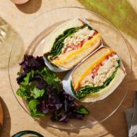 Chicken Salad Melt · Chicken salad with melted cheese, lettuce, and tomato on a seeded roll.