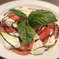 Fresh Mozzarella And Tomatoes · House made fresh fior di latte mozzarella with tomatoes, extra virgin olive and balsamic.