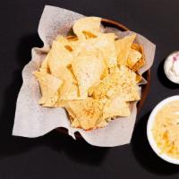 Chips And Queso · Tortilla chips with cheesy queso sauce.