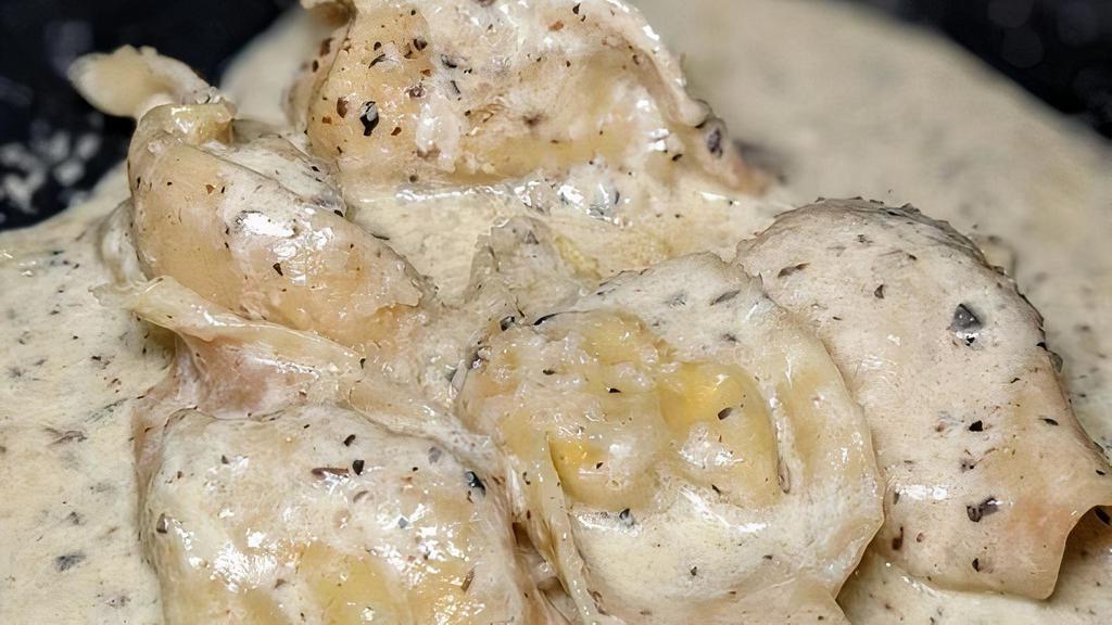 Tortelli · stuffed pasta with burrata and black truffle, tartufata, parmigiano, cream