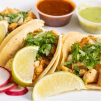 Chicken Taco (3 Pcs) · Tacos topped with fresh onions and cilantro, garnish with a lime wedge and radish, accompani...