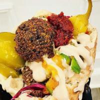 Falafel · Our signature, served with Israeli salad, cabbage salad, hummus, tahina, harissa, sliced pic...