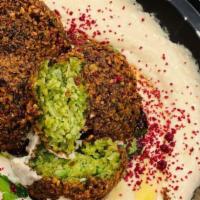 Hummus & Tahina Topped With Falafel · Our signature hummus with tahina, topped with our signature falafel & harissa. Served with a...