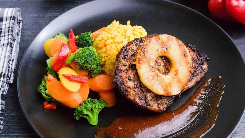 Jamaican Jerk Chicken · A tender chicken breast prepped with jerk spices, quickly grilled to an oven-finish, coated with a Caribbean sauce and topped with a slice of grilled pineapple to balance the heat. Paired with our house-made yellow rice and a bahama vegetable blend.
