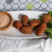 Jalapeño Poppers · Jalapeño peppers stuffed with Cheddar cheese and fried. Served with sour cream and creamy ch...