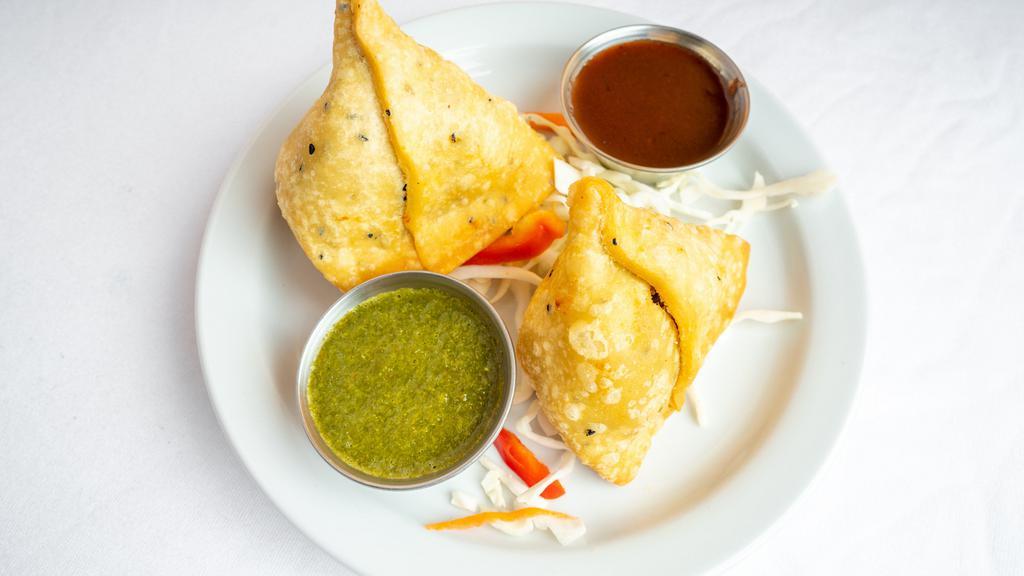 Vegetable Samosa · Mashed potato and green peas marinated with spices and wrapped in wheat dough and fried. (serve 2 pics)