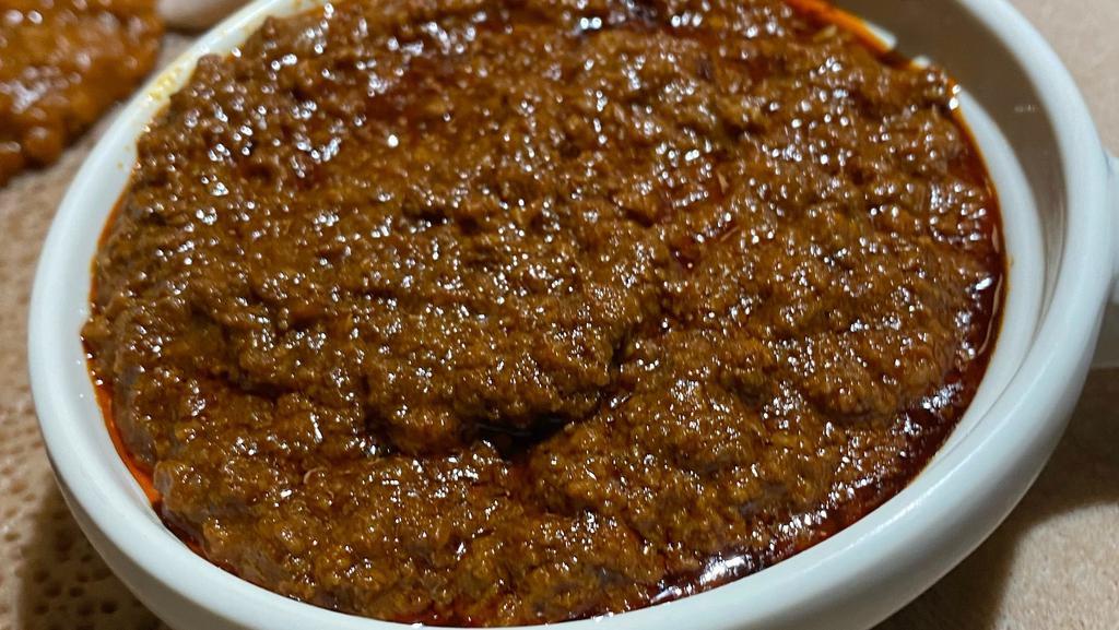 Minchet Abish Spicy · Finely chopped prime beef simmered in a spicy berbere stew. (served with two choices of vegetarian sides and injera)
