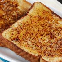 French Toast · Four pieces of gold brown french toast topped with powdered sugar and butter.