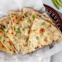 Garlic Naan · Traditional Punjabi style tear-drop shaped white bread spiced with garlic.