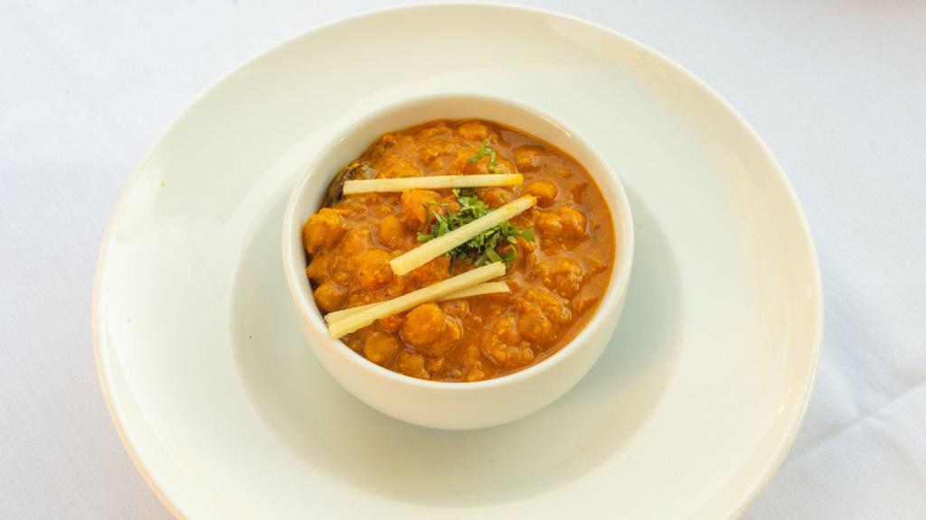 Chana Masala (Vegan) · Gluten Sensitive. White chickpeas tempered with onion, tomatoes, and spices.