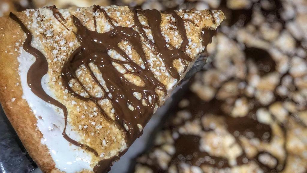 Smores Pie · Sweet dough baked with marshmallow fluff, topped with graham cracker crumbs and a drizzle of Swiss milk chocolate