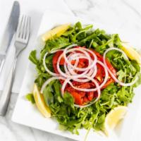 Arugula Salad · Red onion, sun dried tomato, roasted pepper and oil and lemon dressing.