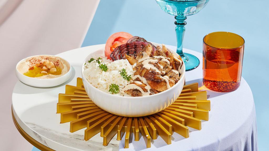 Chicken Shawarma Bowl · Marinated chicken breast over rice with hummus, tomatoes, grilled onions, and drizzled with your choice of sauce.