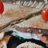 Turkey Sandwich · Turkey, avocado, arugula, tomato, pesto, and mayonnaise on a multigrain toast with side of t...