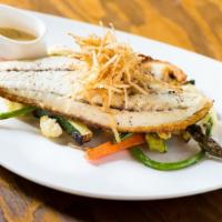 Pan Seared Barramundi · Filet with beurre blanc, tomatoes, and caper sauce topped with fried leeks. Served with a si...