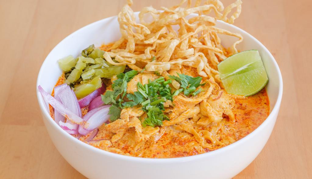 Khao Soi · Northern thai styled curry noodle soup with chicken, red onion, cilantro, dried chili and crispy egg noodle. Hot and spicy.