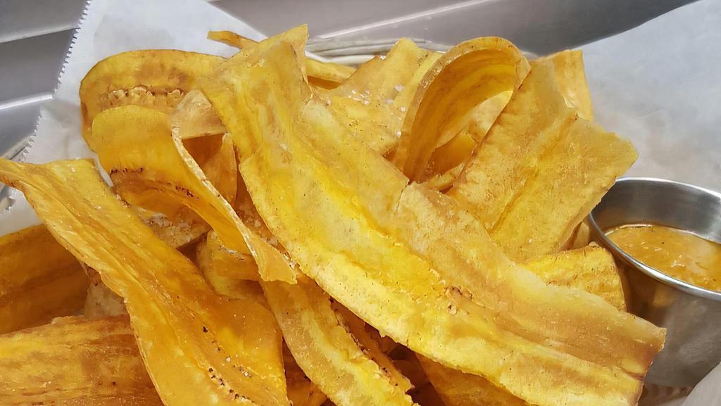 Mariquitas · Thinly sliced plantains cooked until crisp, served with garlic mojo dipping sauce.