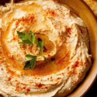 Hummus · Traditional chickpea hummus, spices, EVOO and pita bread.