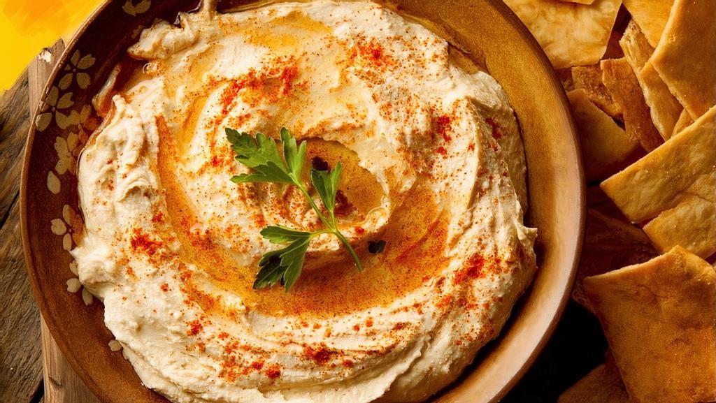 Hummus · Traditional chickpea hummus, spices, EVOO and pita bread.