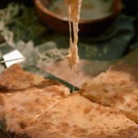 Imeruli Khachapuri · Brick oven baked dough filled with Georgian sulguni cheese.