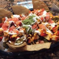 Nachos · Homemade tortilla chips, covered with melted cheese, black beans, diced tomatoes, sour cream...