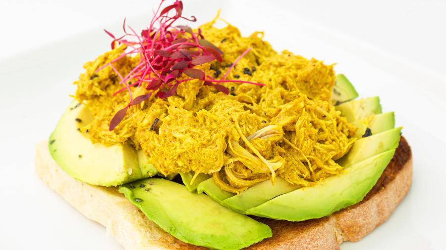 Avo Toast - Curried Chicken · Curried chicken, avocado, and microgreens.