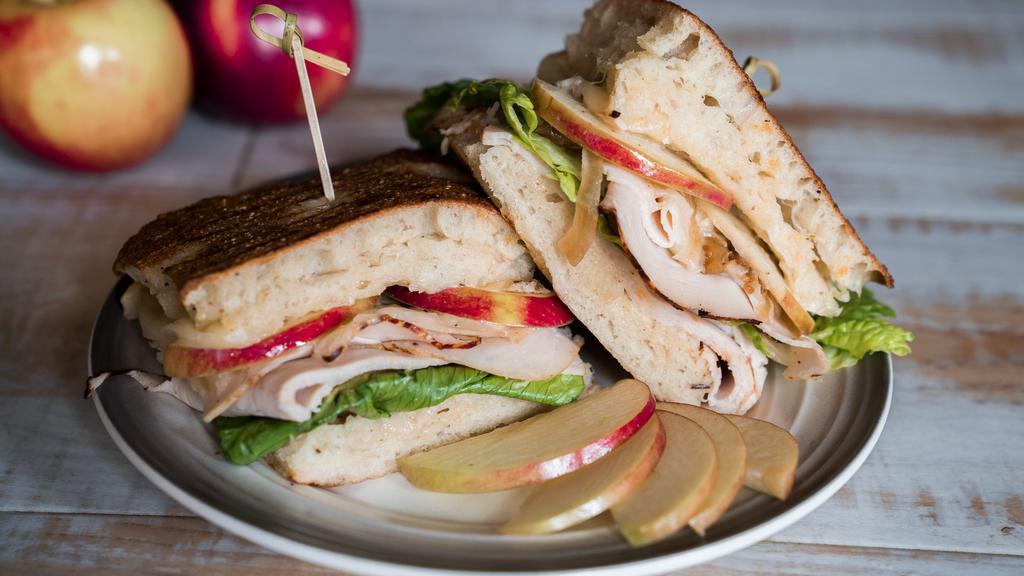 Forbidden Fruit · Honey mustard, grilled turkey, caramelized onions, apples and sharp cheddar cheese, layered on our scratch baked focaccia bread.