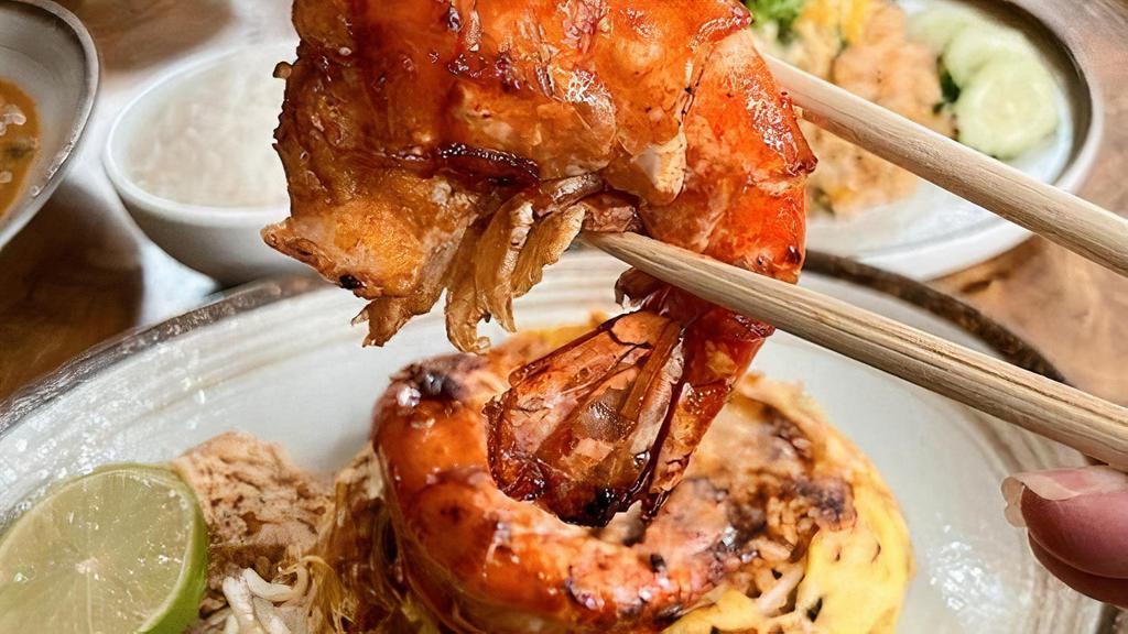 Pad Thai Bo Ran · Stir-fried rice noodles in tamarind sauce with jumbo prawns, shrimp paste, bean sprouts, chive, peanuts, tofu and egg wrapped inside egg net