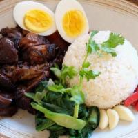 Khao Kha Moo · Stewed pork knuckle over rice served with mushroom, Chinese broccoli boiled egg and garlic c...