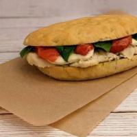 Chicken Caprese · Sliced chicken, basil pesto, roasted tomatoes, and fresh mozzarella on our Tuscan sandwich b...