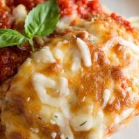 Chicken Parmigiana · Breaded chicken breast topped with tomato sauce, melted mozzarella, basil, and a side of spa...