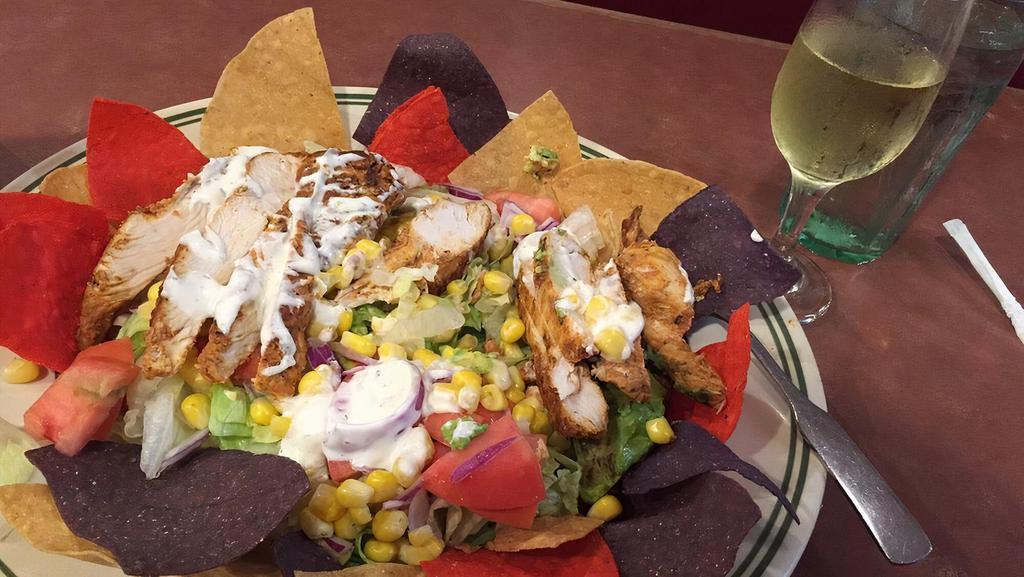 Mexican Fiesta Salad · Leaf lettuce with fresh tomatoes, cheddar, avocado, corn, marinated grilled chicken breast, red onion and ancho chili ranch dressing, topped with corn tortillas.