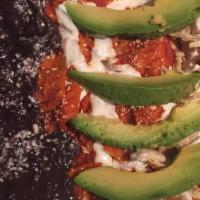 Chilaquiles With Chicken · Tortilla chips in guajillo sauce and spices, served with black refried beans,sliced avocado ...