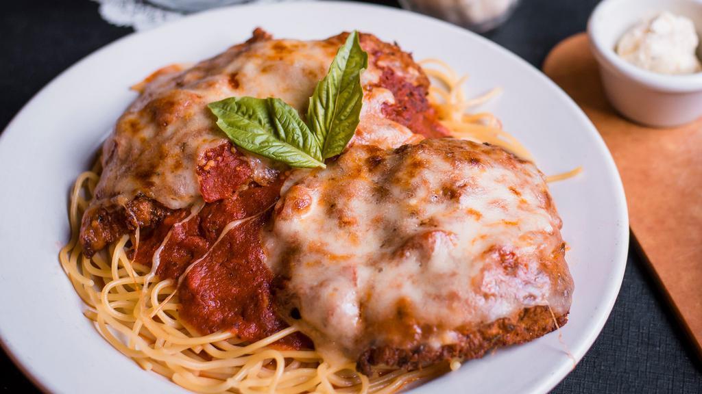 Chicken Parmigiana · Hand-breaded crispy chicken breasts topped with our fresh-made tomato sauce and melted mozzarella cheese.  Served with a side of spaghetti topped with fresh-made tomato sauce,  fresh bread and a choice of soup or a salad. Gluten free spaghetti available upon request.