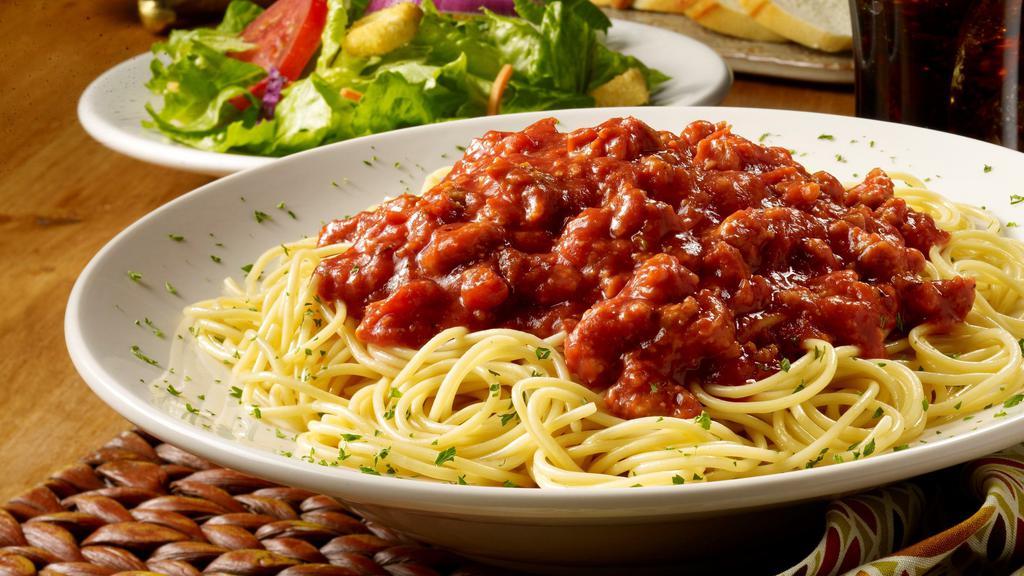 Spaghetti With Meat Sauce · Spaghetti topped with our fresh-made meat sauce teaming with beef, pork, onions, Romano cheese and tomatoes. Order traditional or SPICY!  Served with fresh bread and a choice of soup or a salad.  Gluten free spaghetti available upon request.