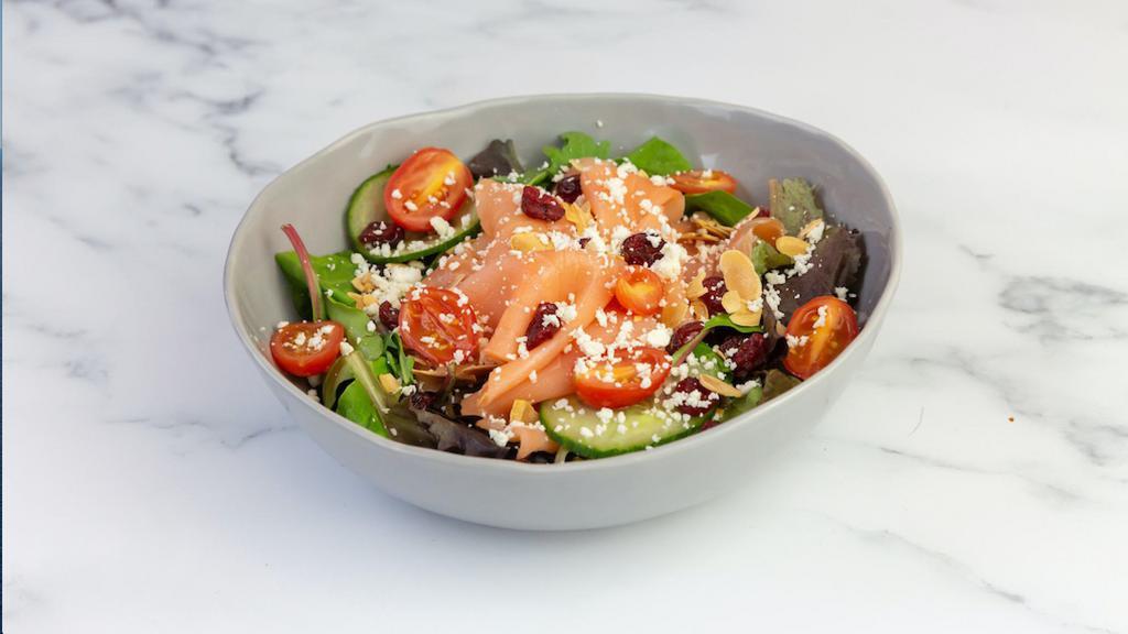 Smoked Salmon Salad · Smoked salmon (raw), toasted almonds, feta cheese, dried cranberries, grape tomatoes, cucumbers, radishes, and mixed greens with ginger dressing.