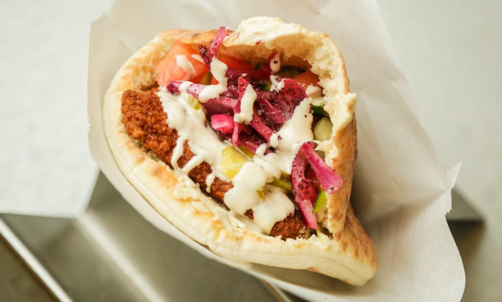 Chicken Cutlet Pita (Schnitzel) · Hummus, israeli chopped salad (cucumber, tomato, red onion, lemon juice, and Evoo), white cabbage, pickles, and sumac onion topped with amba' and tahini. Comes with one pita of your choice.
