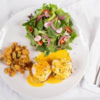 Eggs Benedict (Classic) · Poached eggs, housemade hollandaide sauce, on a bacon biscuit with greens and breakfast pota...