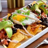 Huevos Rancheros · Corn tortilla chips, black beans, pico de gallo, avocado, over easy egg and a drizzle of spi...