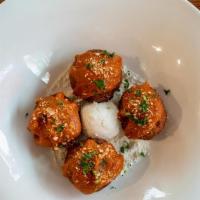 Mini Eggplant Meatballs (Vg) · Four homemade eggplant meatballs sprinkled with tomato sauce over a bed of fresh ricotta