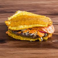 Patacon Chimi · Fried plantain sandwich with homemade pattie, cabbage, tomatoes, red onions, ketchup and our...