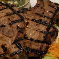 Pork Chop Thai Style · Grilled thin slices of pork chop marinated with lemongrass, galangal garlic, and lime juice.