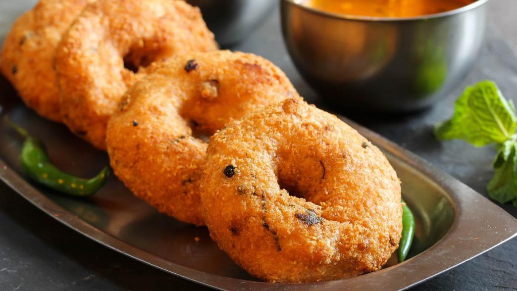 Dahi Vada · Gujarati style fried lentil donuts soaked in spiced yogurt & topped with cilantro chutney & boondi.