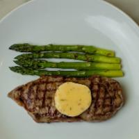 Prime New York Sirloin · Grilled asparagus and baked potato.
