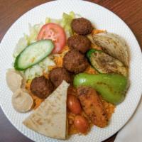 Lamb & Falafel Over Rice · Marinated and cooked Lamb blended with a mix of spices, and served alongside falafel on a be...