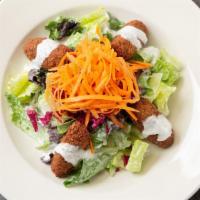 Falafel Salad · Gluten Free, Vegetarian.

Mixed green salad tossed with tahini dressing and topped with fala...