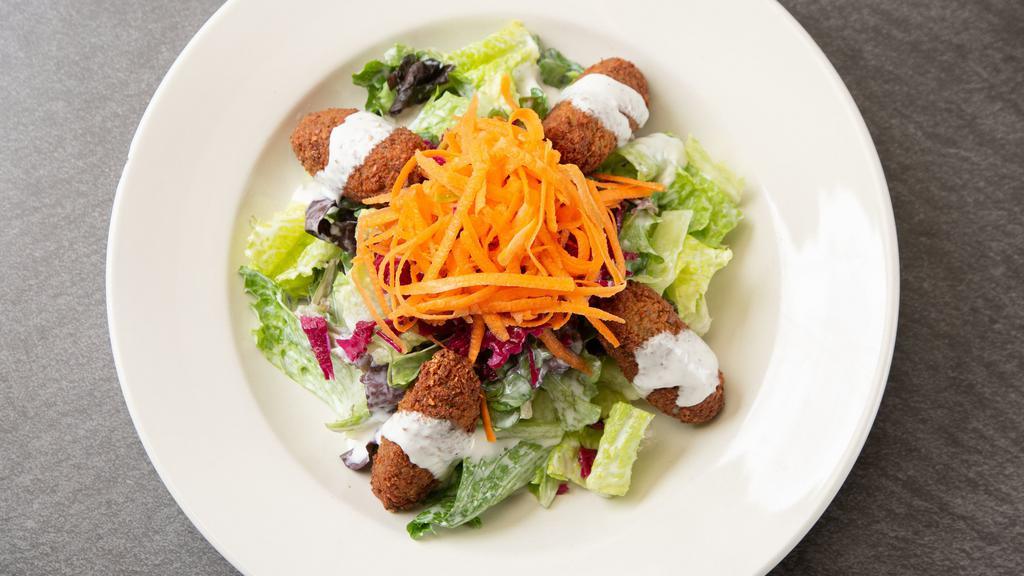 Falafel Salad · Gluten Free, Vegetarian.

Mixed green salad tossed with tahini dressing and topped with falafel. Dressings are mixed in.