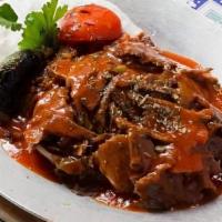 Iskender Kebab · Doner kebab served over pan sauteed pita bread topped with fresh tomato sauce and served wit...