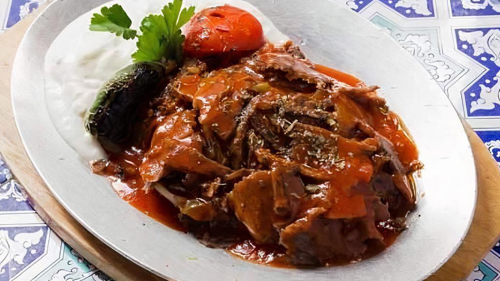 Iskender Kebab · Doner kebab served over pan sauteed pita bread topped with fresh tomato sauce and served with yogurt.